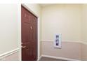 Condo entry with a dark red door and fire extinguisher at 5011 Amber Creek Pl # 102, Indianapolis, IN 46237