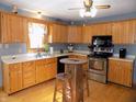 Galley kitchen with wood cabinets, stainless steel appliances, and hardwood floors at 3022 N Alaska Rd, Cloverdale, IN 46120