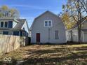 Large backyard with a gray house and wooden fence in the background at 1210 N Rural St, Indianapolis, IN 46201