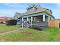 Updated green house with a welcoming front porch and a nicely manicured lawn at 1542 S Alabama St, Indianapolis, IN 46225