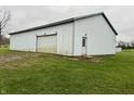 Detached garage with a large overhead door and side entrance at 3149 E 900 S, Flat Rock, IN 47234