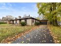 Brick ranch house with a landscaped lawn and attached garage at 3805 Byram Ave, Indianapolis, IN 46208