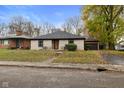 Brick ranch house with a landscaped lawn and attached garage at 3805 Byram Ave, Indianapolis, IN 46208