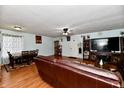 Spacious living room with hardwood floors, leather couches, and a large TV at 7922 S Sherman Dr, Indianapolis, IN 46237