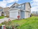 Two-story home with gray siding, brick accents, and a two-car garage at 9715 Violet Cir, Indianapolis, IN 46239