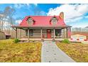 Charming log cabin with red metal roof, porch, and landscaping at 6465 Mt Moriah Rd, Nineveh, IN 46164