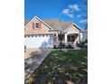 Brick ranch home with two-car garage and landscaped lawn at 4835 Franklin Villas Dr, Indianapolis, IN 46237