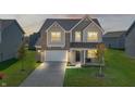 Two-story home with illuminated windows at dusk, showcasing curb appeal at 10797 Walden Ln, Brownsburg, IN 46112