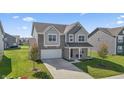 Two-story house with gray and beige siding, a white garage door, and a driveway at 10797 Walden Ln, Brownsburg, IN 46112