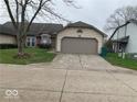 Tan house exterior with a two car garage and landscaping at 4112 Eagle Cove E Dr, Indianapolis, IN 46254