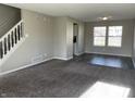 Living room with gray carpeting, vinyl flooring, and a staircase at 7530 Redcliff Rd, Indianapolis, IN 46256