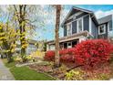 Two-story house with gray siding, red bushes, and fall foliage at 1423 Hoyt Ave, Indianapolis, IN 46203