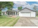 Charming ranch home with gray and white exterior, covered porch, and attached garage at 500 Hickory Dr, Greenfield, IN 46140