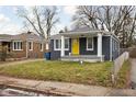 Gray brick house with yellow door, covered porch, and small front yard at 5114 Hillside Ave, Indianapolis, IN 46205