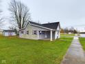 Gray siding house with a covered porch and a spacious yard at 31 S Superior St, Orestes, IN 46063