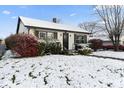 Snow-covered ranch home with dark trim and landscaping at 50 Mckinley St, Shelbyville, IN 46176
