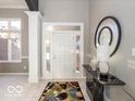 Bright entryway with tile flooring, a console table, and a large mirror at 12954 Water Ridge Dr, Fishers, IN 46055