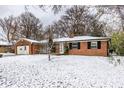 Brick ranch home with attached garage and snow-covered front yard at 6005 Pembroke Pl, Indianapolis, IN 46220