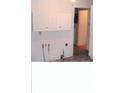 Kitchen needing updates, white cabinets, and a view of the hallway at 3726 N Emerson Ne Ave, Indianapolis, IN 46218