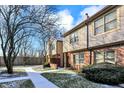 Brick townhouse with walkway, landscaping, and snowy ground at 9464 Maple Way # 27, Indianapolis, IN 46268