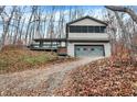A charming two-story home with a large screened porch and attached garage, set on a hillside at 13832 W Old Nashville Rd, Columbus, IN 47201