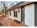 Inviting front entrance with a white door and a wooden deck, surrounded by autumn leaves at 13832 W Old Nashville Rd, Columbus, IN 47201