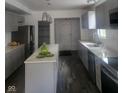 Modern kitchen with gray cabinets, island, stainless steel appliances, and vinyl flooring at 1826 N Dexter St, Indianapolis, IN 46202