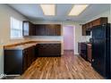 Bright kitchen featuring dark brown cabinets and wood-look flooring at 10938 Delphi Dr, Camby, IN 46113