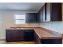 Kitchen with dark brown cabinets, granite countertops, and wood-look flooring at 10938 Delphi Dr, Camby, IN 46113