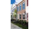 Side view of townhome showcasing brick and siding exteriors, landscaping, and a black metal fence at 718 Kinzer Dr, Carmel, IN 46032