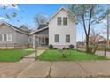 Two-story home with gray and white exterior, and a well maintained lawn at 329 Lincoln St, Indianapolis, IN 46225