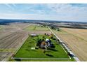 Aerial view of a house and property featuring a large green lawn, outbuildings, and surrounding farmland at 7919 W County Road 100 South, Coatesville, IN 46121