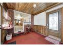 Sunroom with wood paneling, brick wall, and view into kitchen at 80 S Mickley Ave, Indianapolis, IN 46241
