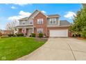 Two-story house with a brick and gray exterior, attached garage, and manicured lawn at 4351 Chase Cir, Zionsville, IN 46077