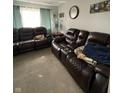 Living room with two dark brown leather reclining sofas and carpeted floors at 4515 Rainbow Ct, Indianapolis, IN 46221