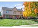 Two-story house with a brick and beige exterior, and nicely landscaped lawn at 4677 Bedford Ct, Carmel, IN 46033