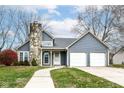 Two-story blue house with stone facade and attached garage at 3502 Oak Tree Cir, Indianapolis, IN 46227