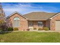 Brick ranch home with a two-car garage and well-maintained landscaping at 5138 Imperial Dr, Columbus, IN 47203