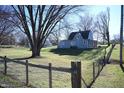 The house is nestled in a spacious backyard with a large tree at 3235 Adams St, Indianapolis, IN 46218