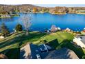 Aerial view showcasing lakefront home, landscaping, and surrounding neighborhood at 9454 Raintree S Dr, Columbus, IN 47201