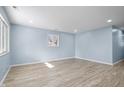 Spacious living room featuring light blue walls and wood-look flooring at 11320 Stoeppelwerth Dr, Indianapolis, IN 46229