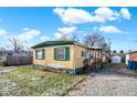 Tan mobile home with green trim and a partially visible yard at 33 Miami Dr, Noblesville, IN 46062