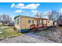 Yellow mobile home with green trim and a wooden porch at 33 Miami Dr, Noblesville, IN 46062