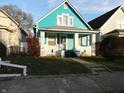 Cute teal bungalow with white trim, porch, and small yard at 443 N Centennial St, Indianapolis, IN 46222