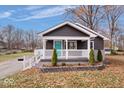 Ranch home with a landscaped front yard and teal door at 940 N Bazil Ave, Indianapolis, IN 46219