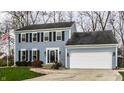 Two-story blue house with white garage and manicured lawn at 104 Elderberry Cir, Noblesville, IN 46062