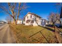 House exterior showcasing a large tree and grassy yard with fallen leaves at 126 W 29Th St, Anderson, IN 46016