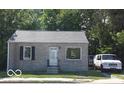 Front view of a ranch house with a tan brick exterior and a white door at 3716 N Emerson Ne Ave, Indianapolis, IN 46218