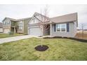 Gray house with white accents, a two-car garage, and a landscaped lawn at 5607 Tart Blvd, Indianapolis, IN 46239