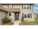 Front entrance of a beige two-story house with green shutters at 924 Delegate Dr, Shelbyville, IN 46176